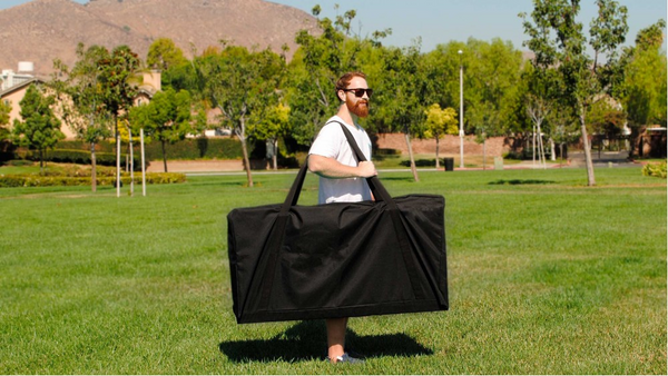 Guy carrying heavy cornhole boards